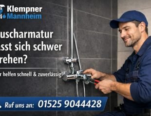 Klempner in blauer Arbeitskleidung repariert eine Duscharmatur im Bad – Klempner Mannheim